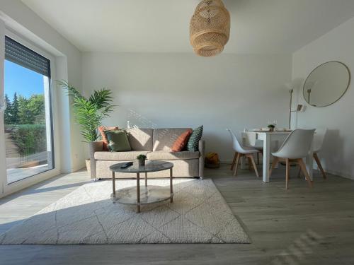 a living room with a couch and a table at Modernes und helles Mini-Haus in Peine in Peine