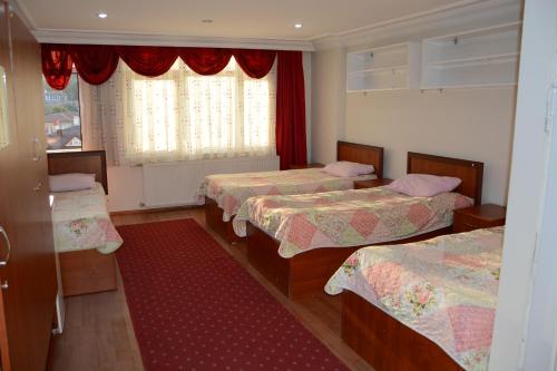 a room with three beds and a window at GOLD OTEL KASTAMONU in Kastamonu