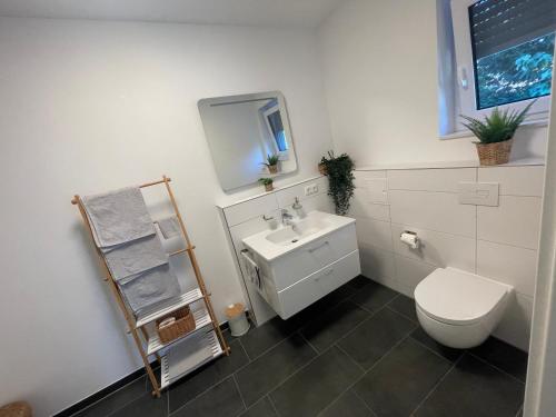 a bathroom with a white toilet and a sink at Modernes und helles Mini-Haus in Peine in Peine