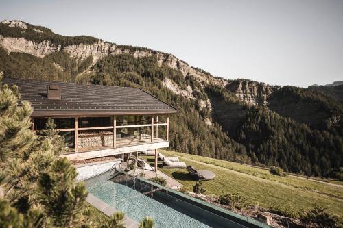 a house with a pool in front of a mountain at Luxury Chalet Vilaiet in Ortisei