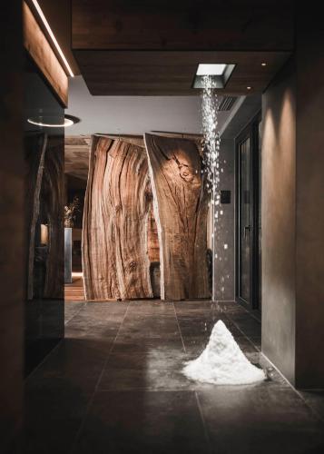 a room with a large wooden wall with a tree at Luxury Chalet Vilaiet in Ortisei
