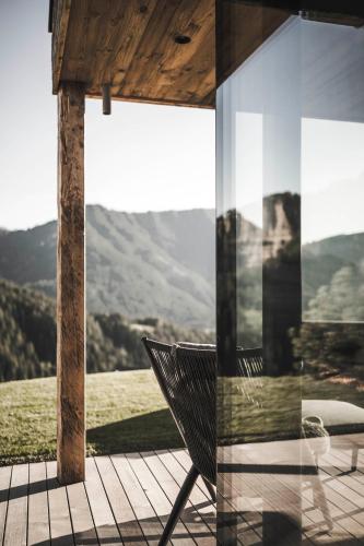 a chair on a porch with a view of the mountains at Luxury Chalet Vilaiet in Ortisei