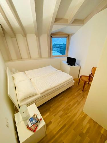 a small bedroom with a bed and a desk at ATTICO61 in Arco