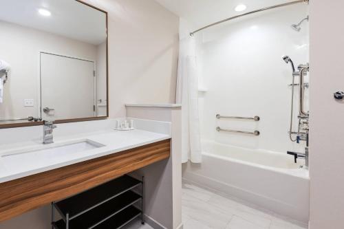 a bathroom with a sink and a tub and a mirror at Fairfield Inn & Suites by Marriott Goshen in Goshen