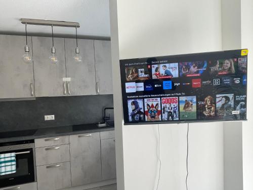 a kitchen with a tv hanging on the wall at Modernes und helles Mini-Haus in Peine in Peine