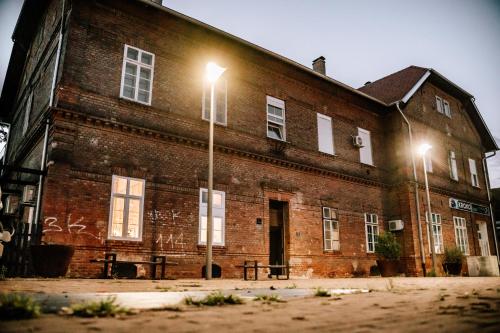 un bâtiment en briques avec deux feux de rue devant lui dans l'établissement Apartman Saturn, à Osijek