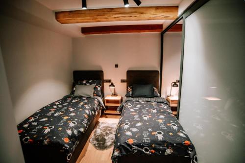 2 Betten in einem kleinen Zimmer mit 2 Betten sidx sidx sidx sidx in der Unterkunft Apartman Saturn in Osijek