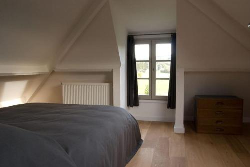 1 dormitorio con cama y ventana en Le Chaperon Villa, en Tellin