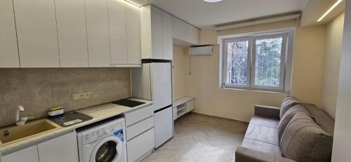 a living room with a couch and a kitchen at Близко к метро in Yerevan