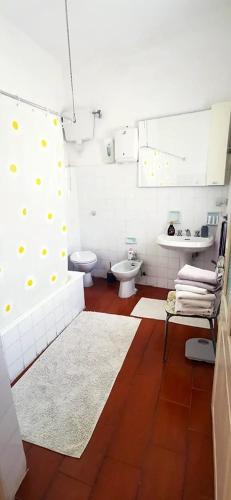 a bathroom with a toilet and a tub and a sink at La corte di Quiliano in Quiliano