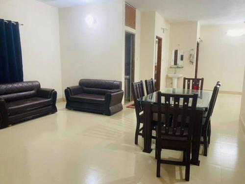a living room with a table and chairs and a couch at Cheapest Apartment in Dhaka in Dhaka