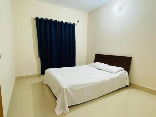 a bedroom with a bed with a blue curtain at Cheapest Apartment in Dhaka in Dhaka