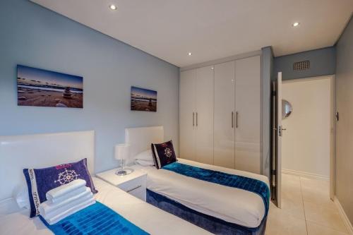 a bedroom with two beds and a sliding glass door at Sea Lodge G01 in Durban