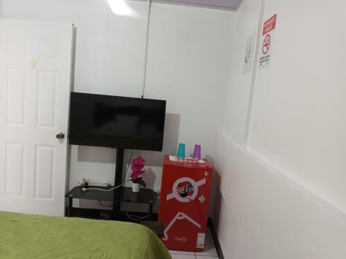 a bedroom with a bed and a tv on a wall at Gran Hotel Desamparados in Desamparados