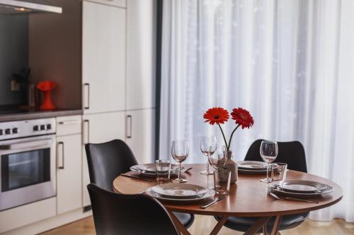 a dining room table with a red flower on it at The Circus Apartments in Berlin