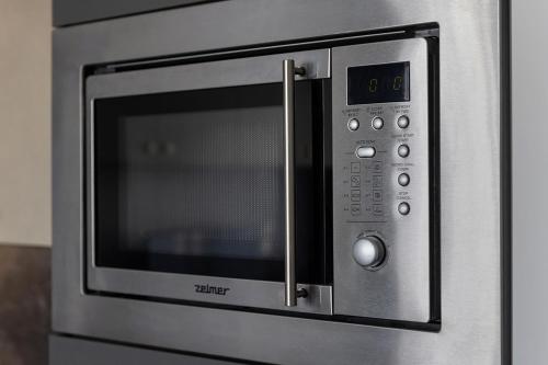 a stainless steel microwave oven in a kitchen at Apartament LUX przy Pileckiego 34 in Biała Podlaska