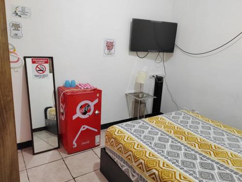 a room with a bed and a tv on the wall at Gran Hotel Desamparados in Desamparados