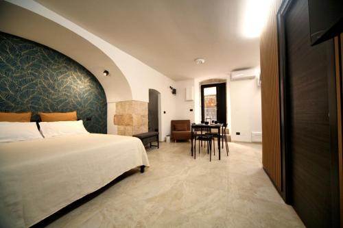 a hotel room with a bed and a dining room at Appartamento Maison De Ruelle in Barletta