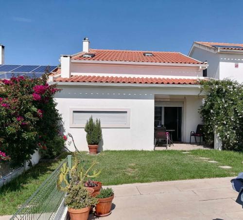 a white house with plants in a yard at Moradia no Meco in Sesimbra