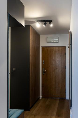 a hallway with a door and a wooden door at Apartament LUX przy Pileckiego 34 in Biała Podlaska