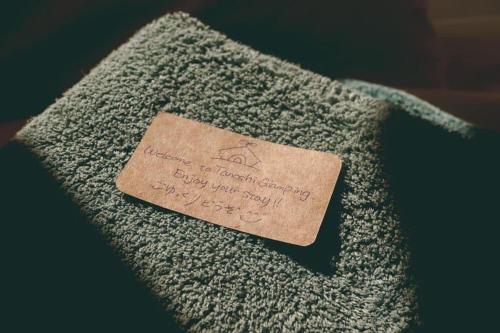 a piece of paper on the side of a towel at Tanoshi Glamping In Khao Sok in Khao Sok