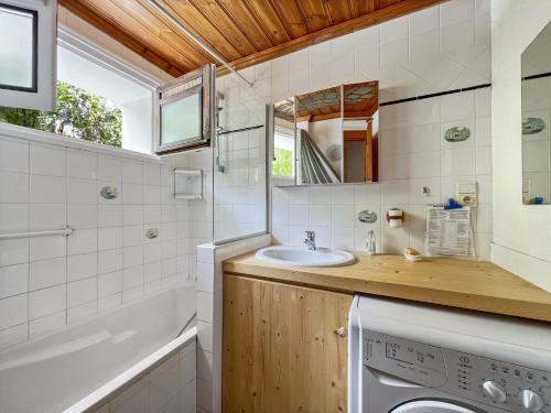 a bathroom with a sink and a washing machine at Appartement 5/6 Pers centre Carroz (ARB 40) in Les Carroz d'Araches