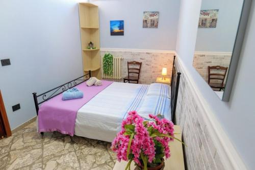 1 dormitorio con 1 cama con sábanas rosas y flores en Casa Venere Luxury Apartment, en Giuggianello