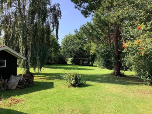 a yard with a tree and a shed in the grass at 6 person holiday home in Nykøbing M-By Traum in Alsted