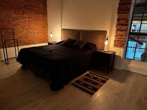 a bedroom with a bed and a brick wall at Pucara Apart - Habitaciones con baño privado in Corrientes