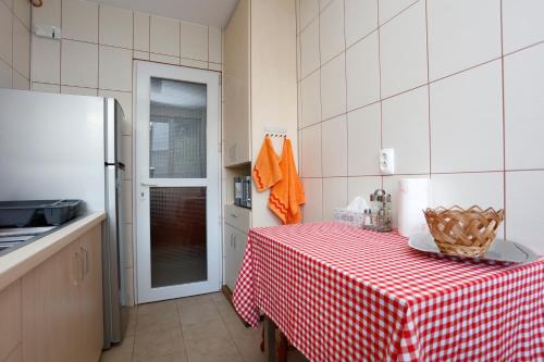 eine Küche mit einem Tisch mit einem roten und weißen karierten Tischtuch in der Unterkunft My Cozy Place in Bukarest