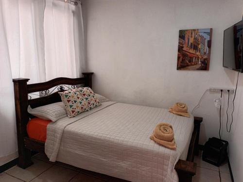 a bedroom with a bed with two hats on it at Gran Hotel Desamparados in Desamparados