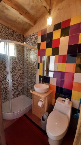 a bathroom with a toilet and a shower and a sink at Hostal Crisol in Lo Valdés