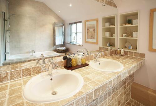 a bathroom with two sinks and a bath tub at The White House in Little Weighton