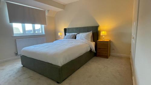 a bedroom with a large bed and a window at Lovely 3-Bedroom Townhouse in Harold Wood