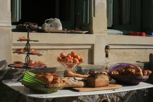 un tavolo con pane e altri prodotti alimentari di Le Domaine du Meunier a Mortagne-sur-Gironde