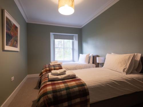 a bedroom with a bed and a window at Lassintullich House East Wing in Kinloch Rannoch