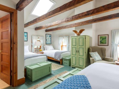 a bedroom with two beds and a chair at Old Stagecoach Inn in Waterbury