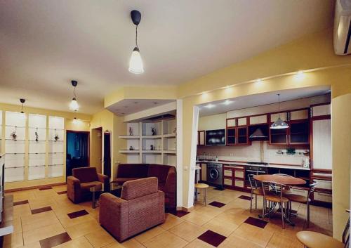 Il comprend une cuisine et un salon avec une table et des chaises. dans l'établissement Two-bedroom apartment in the heart of Chisinau, à Chişinău