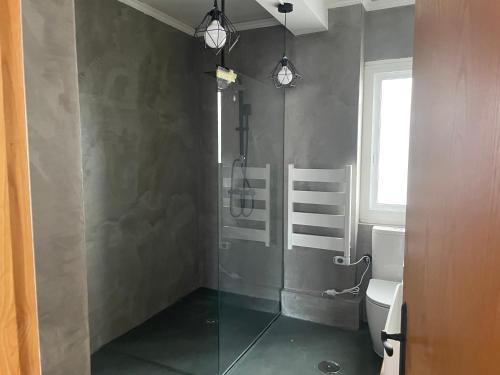 ein Badezimmer mit einer Dusche und einem WC sowie zwei Leuchten in der Unterkunft TikaHome in Marín
