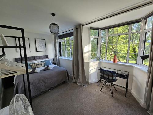 1 dormitorio con 1 cama, escritorio y ventanas en The Regent House, en Brighton & Hove