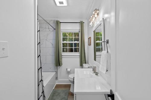uma casa de banho branca com um lavatório e um WC em Dog-Friendly, Renovated 3 Bedroom Home! em Jacksonville