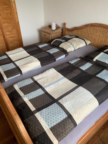een bed met een zwart-witte quilt bij Wohnen in Schlossnähe in Schwerin