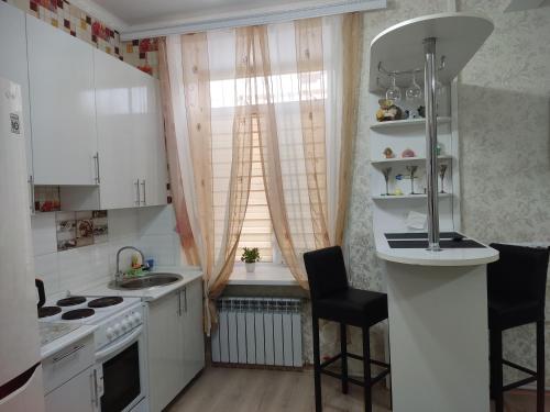 巴爾喀什的住宿－Аренда квартиры，厨房配有白色橱柜、水槽和窗户。