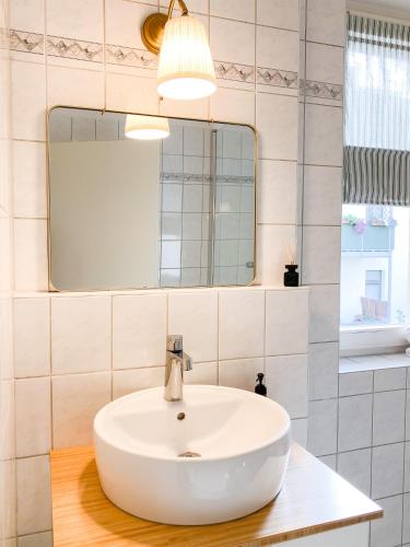 La salle de bains est pourvue d'un lavabo blanc et d'un miroir. dans l'établissement Rooftop Feeling erleben Sie Leipzig von oben, à Leipzig