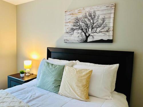 1 dormitorio con 1 cama con una pintura de árbol en la pared en Charming Retreat in Oak Park, IL Modern Comforts, en Oak Park