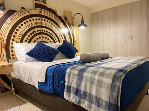 ein Schlafzimmer mit einem großen Bett mit blauen Kissen in der Unterkunft Magnifico apartamento in Bogotá
