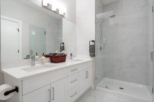 bagno bianco con lavandino e doccia di Luxury Hillhurst Home Central Location 3 Br a Calgary