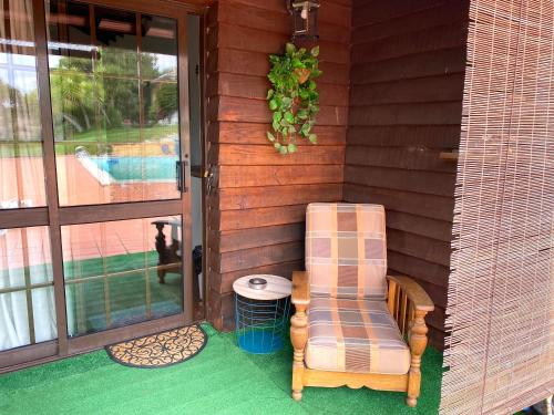 una veranda con sedia, tavolo e finestra di Poolside Wooden House a Moçarria