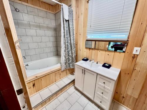 La salle de bains est pourvue d'une baignoire, d'un lavabo et d'une baignoire. dans l'établissement Creekside Haven, à Gatlinburg