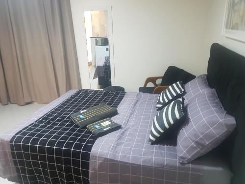 a bed with pillows on it in a room at Studio 215 Campinas SP in Campinas